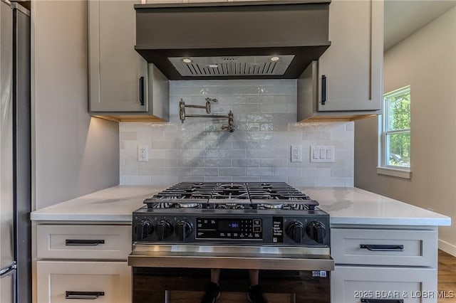 312 Woodland Pt, Linn Creek, MO 65052 - kitchen featuring stainless steel appliances, wall chimney range hood, decorative backsplash, wood finished floors, and light stone counters