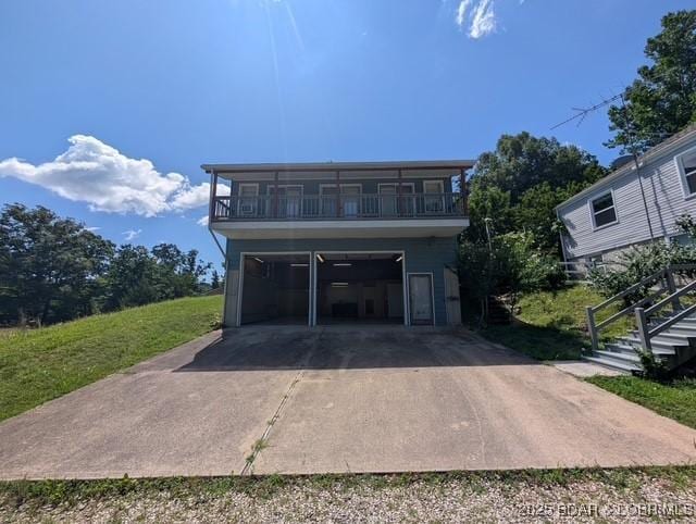 742 Pappys Pt, Sunrise Beach, MO 65079 - view of front of house featuring an attached garage, stairs, and a balcony