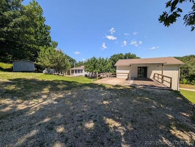 742 Pappys Pt, Sunrise Beach, MO 65079 - view of grassy yard with a storage shed and a patio area