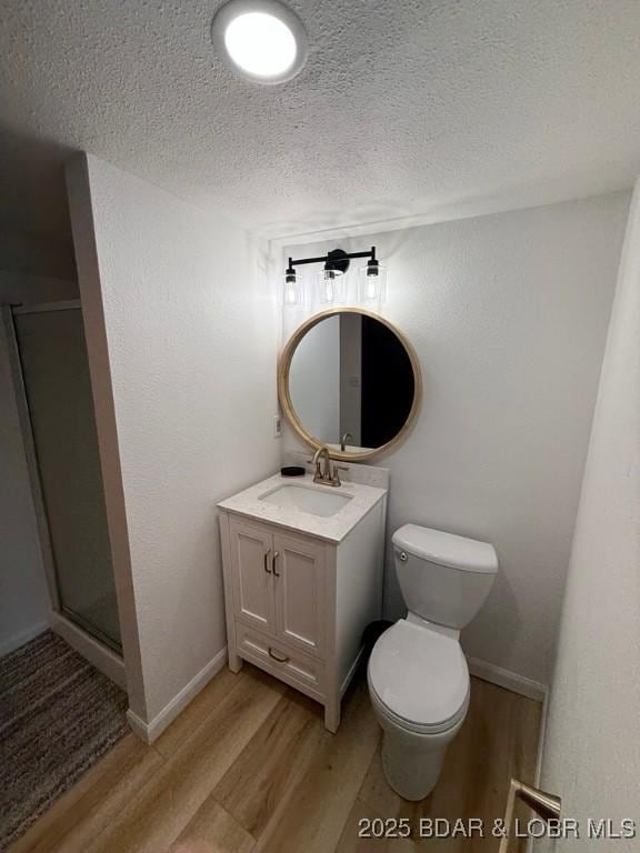 5185 Lois Ln, Osage Beach, MO 65065 - full bathroom featuring wood finished floors, vanity, a shower stall, and a textured ceiling