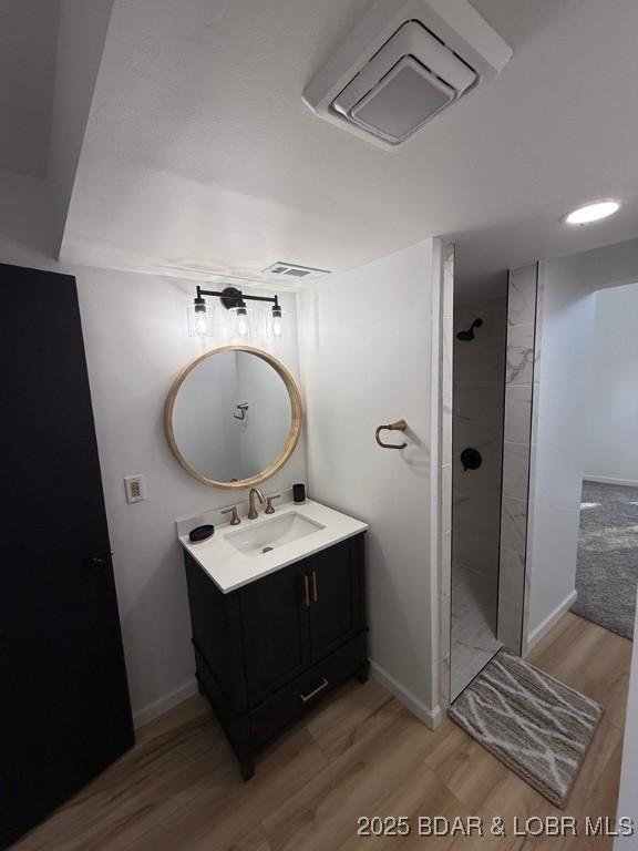 5185 Lois Ln, Osage Beach, MO 65065 - full bath featuring wood finished floors, vanity, and tiled shower