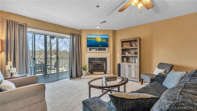 1481 Ledges Dr Unit B14, Osage Beach, MO 65065 - living room featuring carpet, ceiling fan, and a fireplace with raised hearth