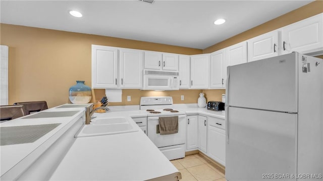 1481 Ledges Dr Unit B14, Osage Beach, MO 65065 - kitchen with white appliances, white cabinets, light countertops, light tile patterned floors, and recessed lighting