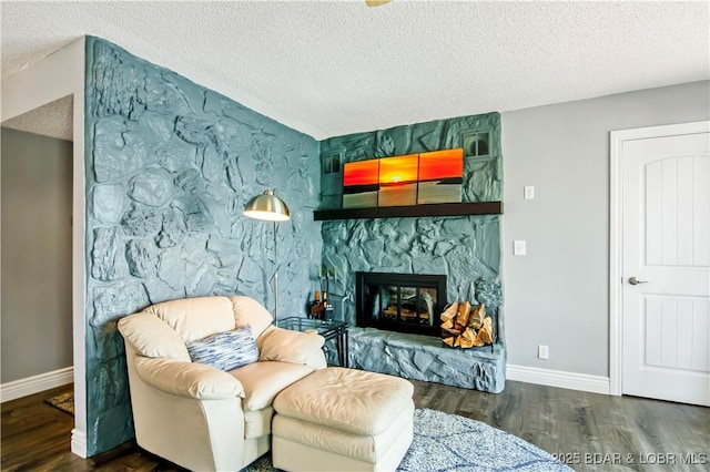889 Malibu Rd Unit 63, Osage Beach, MO 65049 - living room featuring a textured ceiling, wood finished floors, a stone fireplace, and an accent wall
