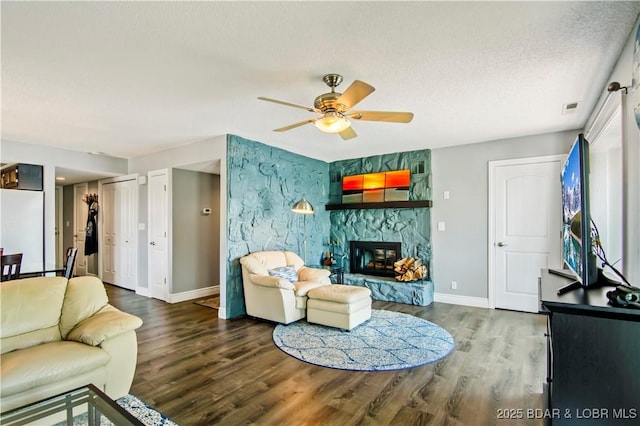 889 Malibu Rd Unit 63, Osage Beach, MO 65049 - living room featuring ceiling fan, wood finished floors, a fireplace, an accent wall, and a textured ceiling