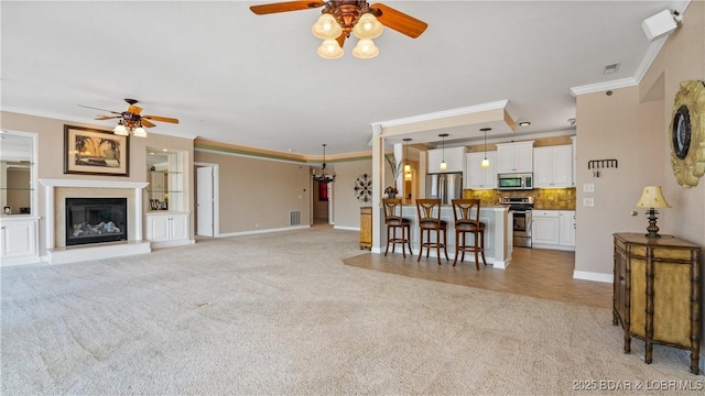 895 Summer Place Dr Unit 3A, Camdenton, MO 65020 - living room with ceiling fan, crown molding, light carpet, and a glass covered fireplace