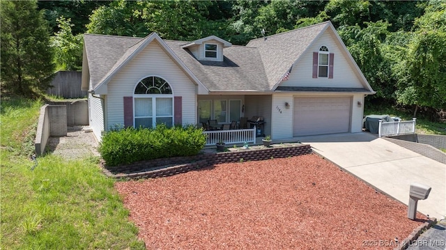 1126 Buckingham Dr, Camdenton, MO 65020 - view of front facade with covered porch, driveway, a shingled roof, and a garage