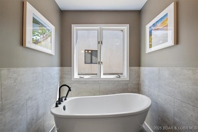 576 Racquet Club Dr Unit 407, Lake Ozark, MO 65049 - bathroom featuring a soaking tub, tile walls, and a wainscoted wall