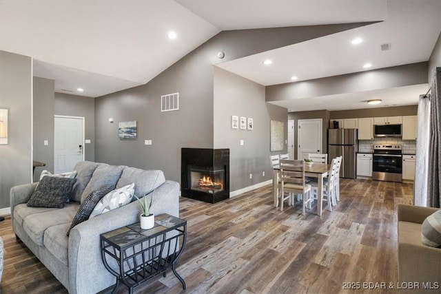 576 Racquet Club Dr Unit 407, Lake Ozark, MO 65049 - living room with lofted ceiling, wood finished floors, a glass covered fireplace, and recessed lighting