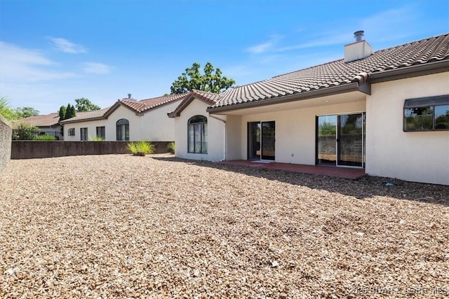 576 Racquet Club Dr Unit 407, Lake Ozark, MO 65049 - back of house with a tiled roof, stucco siding, and a chimney