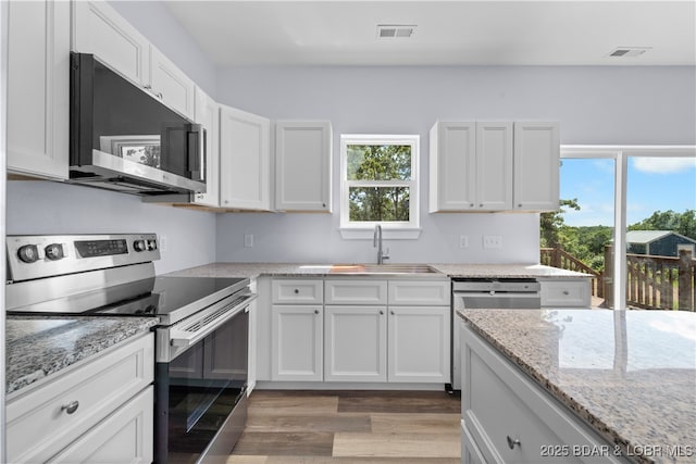 40 Walnut Ct, Eldon, MO 65026 - kitchen featuring appliances with stainless steel finishes, light wood-type flooring, white cabinetry, and light stone counters