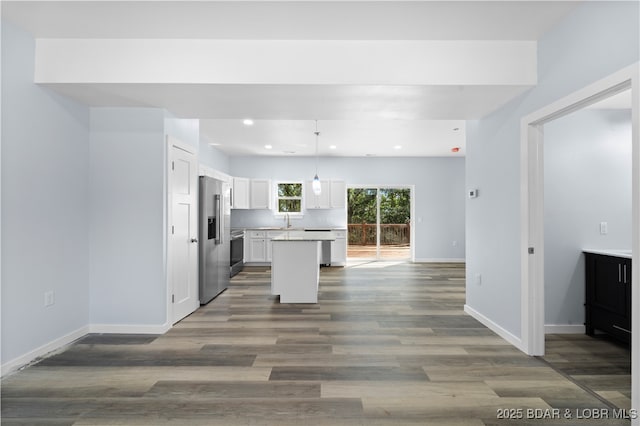40 Walnut Ct, Eldon, MO 65026 - kitchen with high end refrigerator, white cabinetry, a center island, stove, and dark wood finished floors