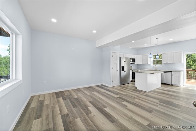 40 Walnut Ct, Eldon, MO 65026 - kitchen with appliances with stainless steel finishes, a center island, white cabinetry, light wood-style floors, and light countertops