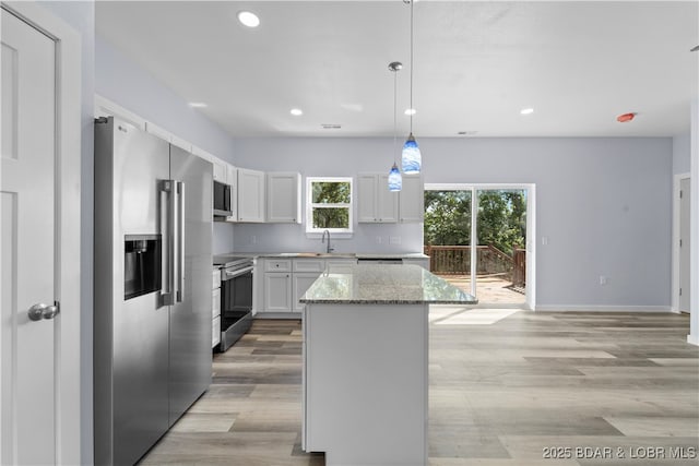 40 Walnut Ct, Eldon, MO 65026 - kitchen featuring stainless steel appliances, a kitchen island, recessed lighting, light stone counters, and white cabinetry