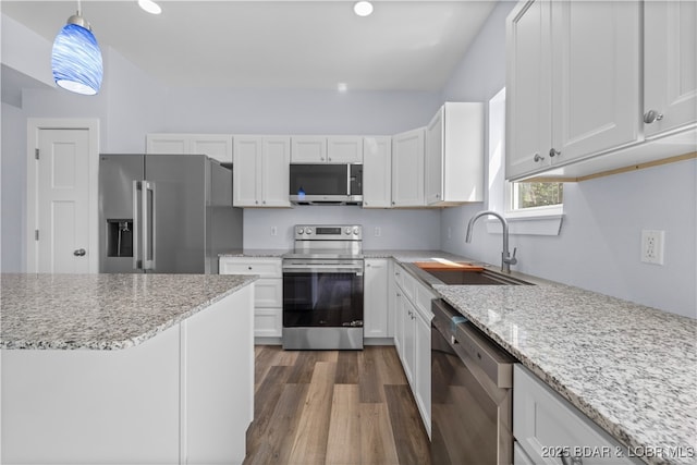 40 Walnut Ct, Eldon, MO 65026 - kitchen featuring appliances with stainless steel finishes, white cabinets, dark wood-style floors, hanging light fixtures, and light stone countertops