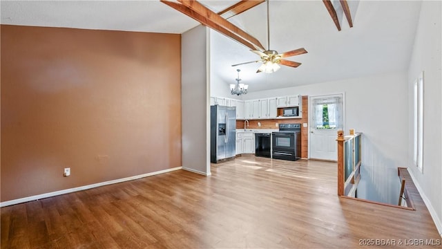 124 Frontier Cir, Linn Creek, MO 65052 - unfurnished living room with a chandelier, light wood-type flooring, high vaulted ceiling, beamed ceiling, and ceiling fan