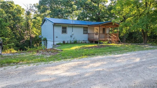 124 Frontier Cir, Linn Creek, MO 65052 - view of front of house featuring a porch, a metal roof, and a front lawn