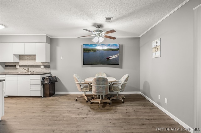 19 Catalpa Ct Unit 2C, Lake Ozark, MO 65049 - dining room featuring a textured ceiling, a ceiling fan, crown molding, and light wood finished floors