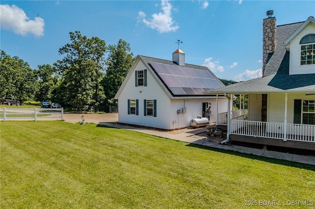 1480 Copperstone Rd, Camdenton, MO 65020 - rear view of house featuring solar panels, a yard, a chimney, and a porch