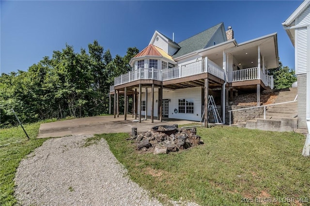 1480 Copperstone Rd, Camdenton, MO 65020 - back of property with an outdoor fire pit, a wooden deck, a lawn, a patio, and a chimney