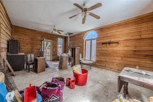 1480 Copperstone Rd, Camdenton, MO 65020 - living area with a wood stove, wooden walls, ceiling fan, and concrete flooring