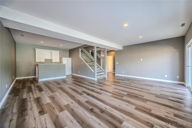 893 Winetavern Rd, Osage Beach, MO 65065 - unfurnished living room featuring stairway, light wood finished floors, and recessed lighting