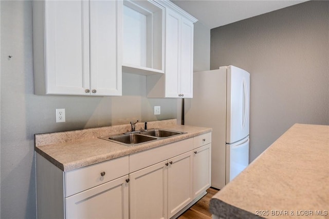 893 Winetavern Rd, Osage Beach, MO 65065 - kitchen featuring white cabinets, light countertops, and freestanding refrigerator