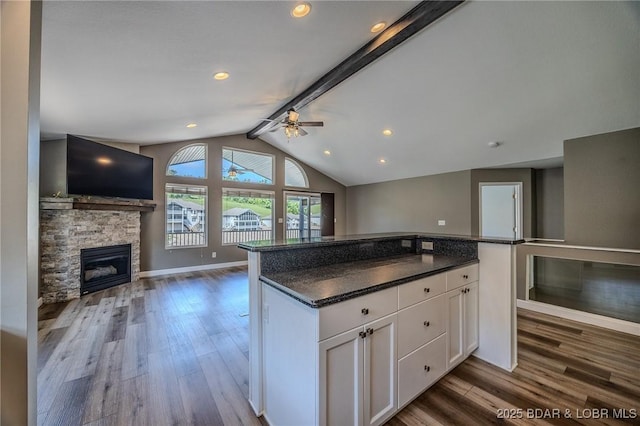 893 Winetavern Rd, Osage Beach, MO 65065 - kitchen featuring open floor plan, wood finished floors, a ceiling fan, white cabinetry, and a fireplace