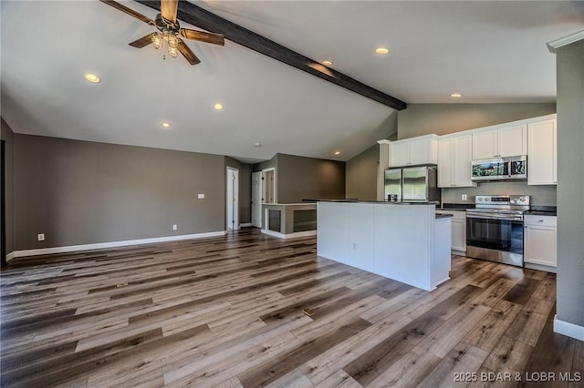 893 Winetavern Rd, Osage Beach, MO 65065 - kitchen featuring stainless steel appliances, dark countertops, beamed ceiling, white cabinetry, and open floor plan