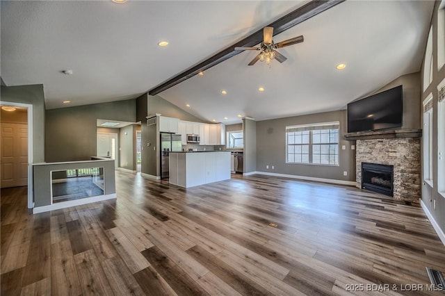 893 Winetavern Rd, Osage Beach, MO 65065 - unfurnished living room featuring a fireplace, a ceiling fan, beamed ceiling, dark wood-type flooring, and high vaulted ceiling