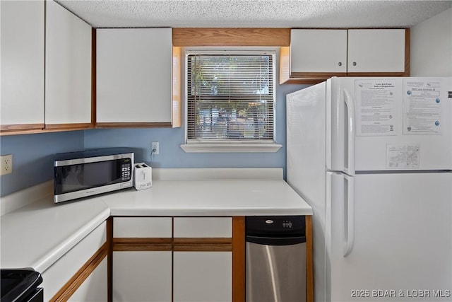 278 Lone Oak Pt Unit 18, Sunrise Beach, MO 65079 - kitchen with freestanding refrigerator, white cabinetry, stainless steel microwave, light countertops, and a textured ceiling