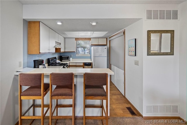 278 Lone Oak Pt Unit 18, Sunrise Beach, MO 65079 - kitchen with freestanding refrigerator, stove, stainless steel microwave, a peninsula, and light countertops