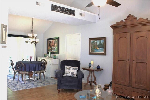891 Azalea Ct, Osage Beach, MO 65065 - dining area with a chandelier, wood finished floors, a ceiling fan, and lofted ceiling