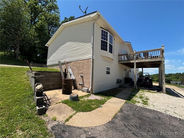 17362 Country Life Rd, Gravois Mills, MO 65037 - view of side of home featuring a deck, a lawn, and driveway