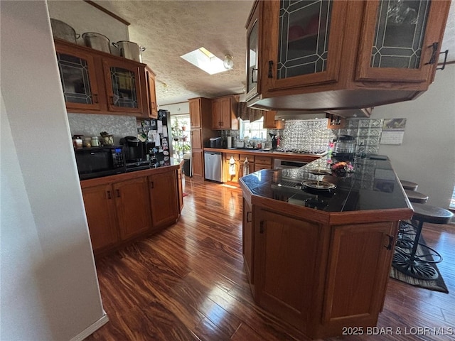 17362 Country Life Rd, Gravois Mills, MO 65037 - kitchen with dark wood-style floors, stainless steel appliances, a peninsula, decorative backsplash, and brown cabinetry