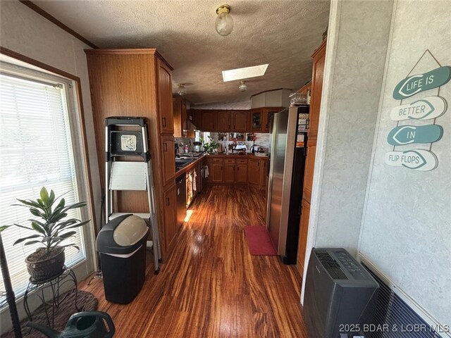 17362 Country Life Rd, Gravois Mills, MO 65037 - kitchen with freestanding refrigerator, dark wood finished floors, a skylight, lofted ceiling, and brown cabinets