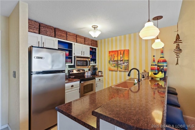 2500 Bay Point Ln Unit 444, Osage Beach, MO 65065 - kitchen featuring appliances with stainless steel finishes, dark countertops, white cabinets, open shelves, and wallpapered walls