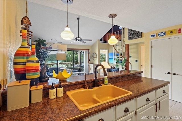 2500 Bay Point Ln Unit 444, Osage Beach, MO 65065 - kitchen with dark countertops, decorative light fixtures, white cabinetry, lofted ceiling, and a ceiling fan