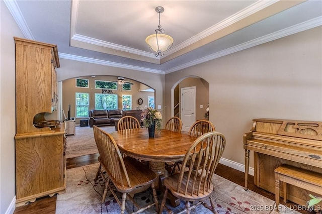 326 Bloomington Dr, Four Seasons, MO 65049 - dining space with arched walkways, crown molding, a tray ceiling, and dark wood-style flooring
