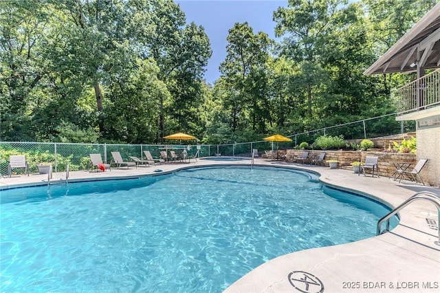 326 Bloomington Dr, Four Seasons, MO 65049 - community pool with a patio and view of wooded area