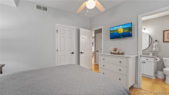 54 Palisades Lakeview Dr Unit 1B, Lake Ozark, MO 65049 - bedroom featuring light wood-style floors, connected bathroom, and a ceiling fan