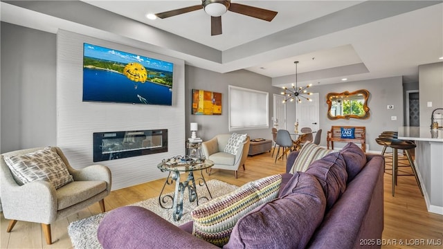 54 Palisades Lakeview Dr Unit 1B, Lake Ozark, MO 65049 - living room with a tray ceiling, a ceiling fan, a chandelier, and wood finished floors