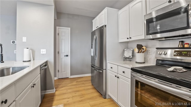 54 Palisades Lakeview Dr Unit 1B, Lake Ozark, MO 65049 - kitchen featuring stainless steel appliances, light wood finished floors, white cabinetry, and light countertops