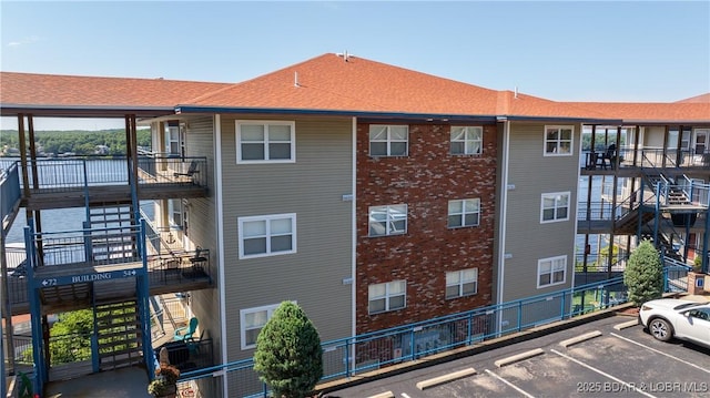 54 Palisades Lakeview Dr Unit 1B, Lake Ozark, MO 65049 - view of building exterior featuring uncovered parking and a water view