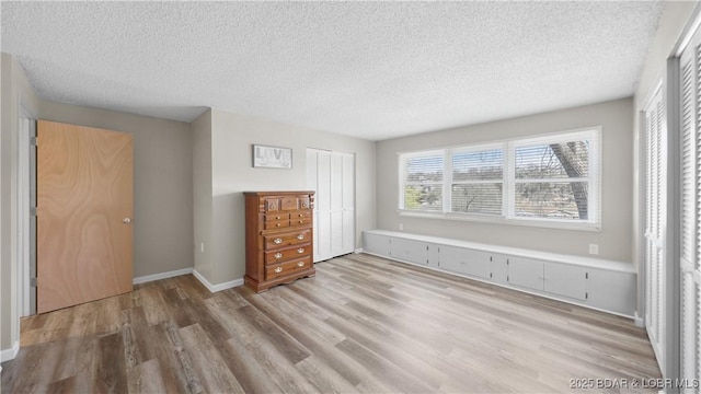 160 Bridgeview Dr, Camdenton, MO 65020 - unfurnished bedroom featuring wood finished floors, a textured ceiling, and a closet