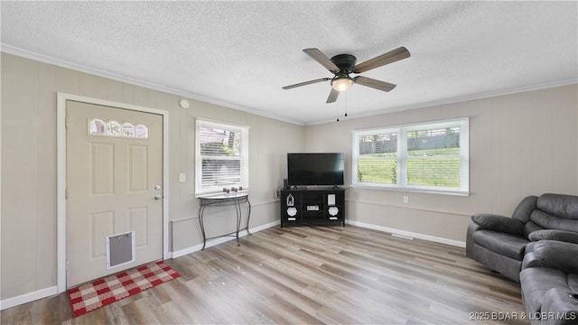 160 Bridgeview Dr, Camdenton, MO 65020 - living room with crown molding, wood finished floors, healthy amount of natural light, ceiling fan, and a textured ceiling