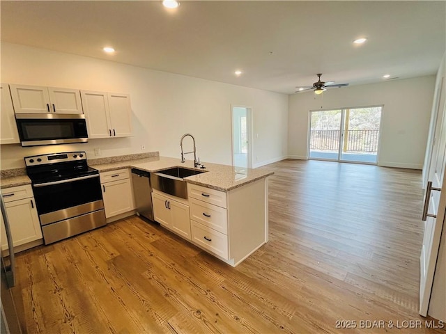 295 Highland Shores Dr Unit 5F, Lake Ozark, MO 65049 - kitchen featuring appliances with stainless steel finishes, a peninsula, ceiling fan, light wood-type flooring, and light stone countertops