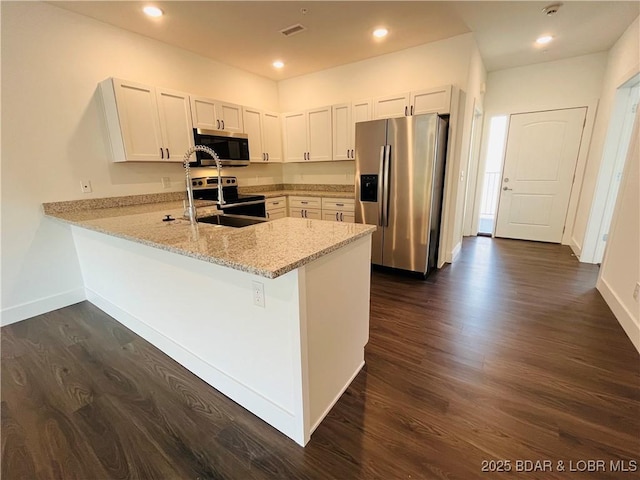 295 Highland Shores Dr Unit 4D, Lake Ozark, MO 65049 - kitchen featuring appliances with stainless steel finishes, a peninsula, dark wood-style flooring, light stone countertops, and white cabinets