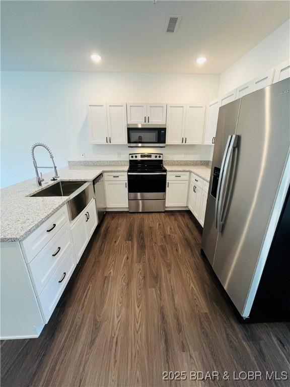 295 Highland Shores Dr Unit 4D, Lake Ozark, MO 65049 - kitchen with stainless steel appliances, dark wood-type flooring, a peninsula, white cabinets, and recessed lighting