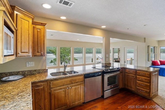 97 Random Rd, Edwards, MO 65326 - kitchen featuring stainless steel appliances, dark wood-style floors, plenty of natural light, light stone counters, and recessed lighting